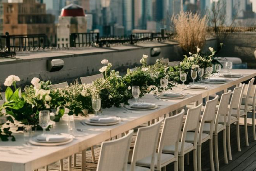 A beautifully decorated banquet space with tables adorned in vibrant floral arrangements and an enchanting overhead display of blossoms.